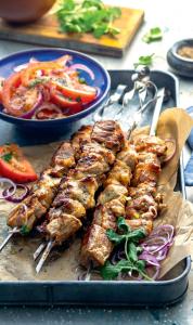 a tray of food with meat and vegetables on a table at Sadyba Domashniy zatyshok in Pilipets