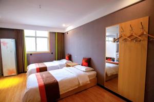 um quarto de hotel com duas camas e um espelho em JUN Hotels Hebei Hengshui Shenzhou Bus Station em Hengshui