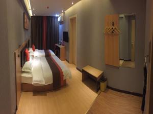 a hotel room with a bed and a mirror at JUN Hotels Dezhou Decheng District Xinhu Park Pedestrian Street in Dezhou