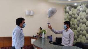 zwei Männer mit Masken in einem Büro mit Ventilator in der Unterkunft The Maple Leaf @ DLF Cyber City in Gurgaon