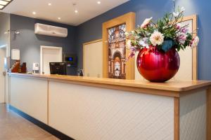 a vase with flowers on the counter of a salon at Trip Inn Eden Antwerpen in Antwerp