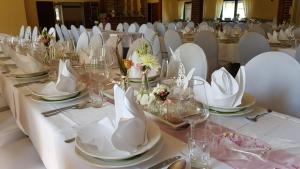 einen langen Tisch mit weißen Tellern und Servietten darauf in der Unterkunft Gasthof Pritzier in Pritzier