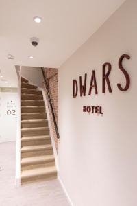 a staircase in a hotel with a sign on the wall at Hotel Dwars in Amsterdam