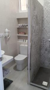 a white bathroom with a toilet and a shower at Apartamento Pimienta in Tarifa