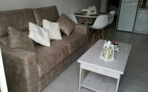 a living room with a brown couch and a table at Apartamento Pimienta in Tarifa