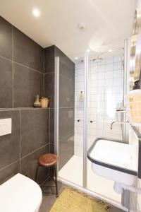 a bathroom with a shower and a toilet and a sink at Hotel Dwars in Amsterdam