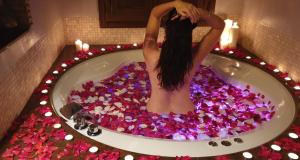 Carenas的住宿－世界空間公寓，浸泡在粉红色花朵的浴缸中的女人