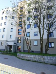 a building with two trees in front of it at Apartament NA KLIFIE in Słupsk