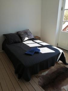 a bedroom with a bed with a blue shirt on it at Cozy Villa-Apartment - Close to Aalborg center - Free citybikes and parking in Aalborg