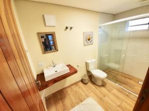 a bathroom with a toilet and a sink and a shower at Empório reserva da serra - Opções de chalés e Hidromassagem in Campos do Jordão +67 photos