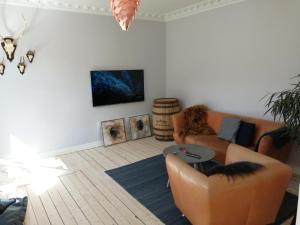 a living room with a couch and a table at Cozy Villa-Apartment - Close to Aalborg center - Free citybikes and parking in Aalborg