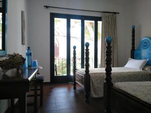 a bedroom with two beds and a desk and a window at Zhimbad B&B by the sea in Cala Ratjada