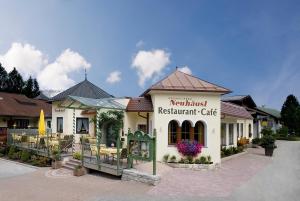 a restaurant with tables and chairs in front of a building at Hotel Neuhäusl - herzlich familiär in Berchtesgaden