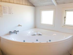 eine weiße Badewanne im Bad mit 2 Fenstern in der Unterkunft Bright Dune View Cottage-By Traum in Bjerregård + 31 Fotos