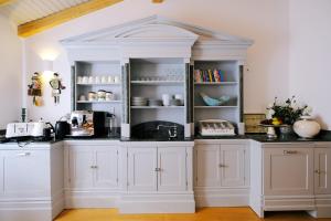 a kitchen with white cabinets and black counter tops at Limnos Experience in Myrina