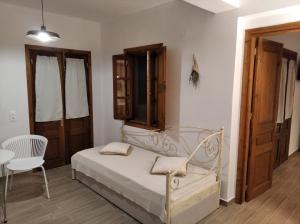 1 dormitorio con 1 cama, 1 mesa y 1 silla en KOMINOS HOUSES en Pátmos