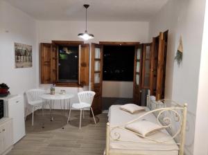 a room with a bed and a table and chairs at KOMINOS HOUSES in Patmos