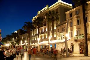 un grupo de personas caminando por una calle frente a un edificio en Riva Waterfront Apartments, en Split