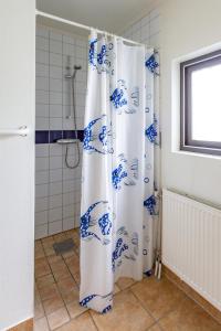 cortina de ducha azul y blanco en el baño en Rödlix Vandrarhem & Camping en Tvååker