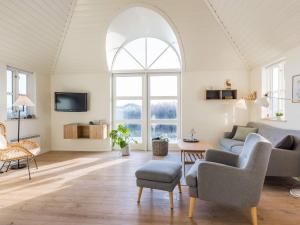 uma sala de estar com uma janela arqueada e um sofá em Holiday home Hvide Sande LXI em Hvide Sande