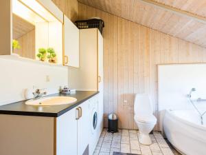 a bathroom with a sink and a tub and a toilet at 6 person holiday home in Hvide Sande in Havrvig +20 photos