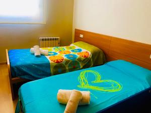 two beds in a room with towels on them at El Far de Palamós - Costa Brava in Palamós