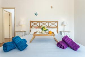 Una cama con mantas azules y moradas y una mesa. en Magic Theatre Faro Center, en Faro