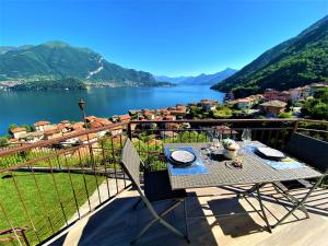 a table and chairs on a balcony with a view of a lake at Il Bellavista in Lezzeno
