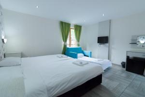 a hotel room with two beds and a window at Elinor Complex in Haskovo +17 photos