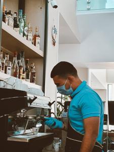 Un uomo in cucina con una maschera e dei guanti. di Nayino Resort Hotel a Mamaia Nord - Năvodari