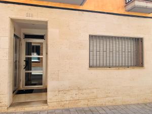 a brick wall with a door and a window at El Far de Palamós - Costa Brava in Palamós