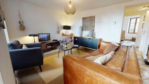a living room with a brown couch and a tv at Sous les Tilleuls PARKING HYPERCENTRE 4-6 Personnes in Colmar +14 photos