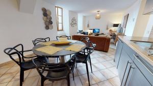 a kitchen and dining room with a table and chairs at Sous les Tilleuls PARKING HYPERCENTRE 4-6 Personnes in Colmar