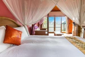 a bedroom with a large white bed with a window at Bali Lover in Jian