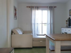 sala de estar con sofá blanco y ventana en Pinar de Don Jesus Sagitario, en Campano