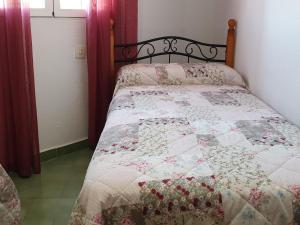 Una cama con edredón en un dormitorio en Pinar de Don Jesus Sagitario, en Campano