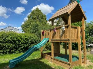 a wooden playground with a slide and a gazebo at Ringhotel Reubel in Zirndorf