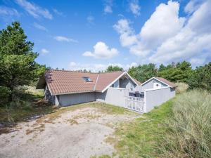 a home with a white fence and a house at Holiday home Blåvand CXLVI in Blåvand