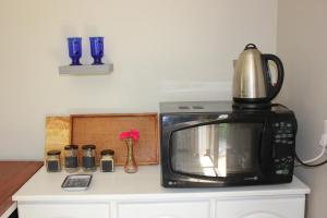 un microondas en la parte superior de una barra de cocina en Karee & Wild Olive Guest Lodge, en Hekpoort