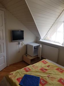 una camera da letto con un letto, una tv e una finestra di LivingPalanga Meta3 a Palanga