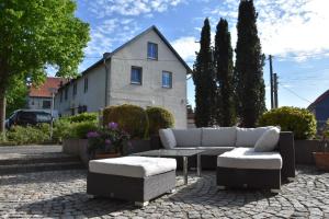 un patio con sofá, mesa y casa en Faupel Ferienwohnung en Mülverstedt
