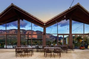 a group of tables and chairs in a pavilion with mountains at Hotel Spa Aguas de los Mallos in Murillo de Gállego