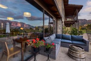 a patio with a blue couch and a table with flowers at Hotel Spa Aguas de los Mallos in Murillo de Gállego