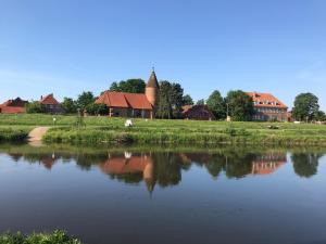 a view of a river with houses and a building at Alter Bahnhof Otersen in Kirchlinteln