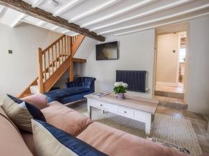 un salon avec un canapé et une table dans l'établissement Lovell Cottage, à Witney