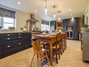 une cuisine avec une grande table et des chaises en bois dans l'établissement Lovell Cottage, à Witney