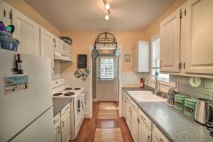 uma cozinha com armários brancos e um frigorífico branco em Coastal Pet-Friendly Cottage Less Than half Mi to Beaches em Chesapeake Beach