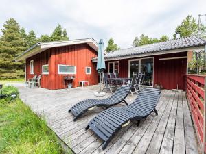 una terraza con sillas, una mesa y un edificio en Holiday home Blåvand CXCIII, en Blåvand