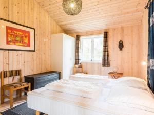 2 camas en una habitación con paredes de madera en Holiday home Blåvand CXCIII, en Blåvand