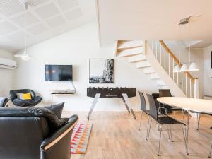 sala de estar con mesa y sillas y escalera en Holiday home Blåvand CXCV, en Blåvand